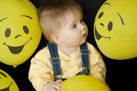 baby girl looking at face on balloons, amazedの写真素材