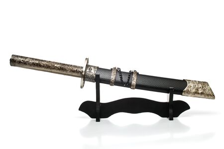 Tanto knife in sheath, lying on a wooden stand, isolated, on white backgroundの写真素材