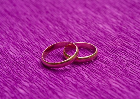 Two wedding rings over purple