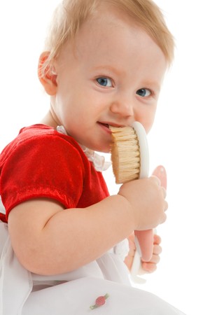 Portrait of a lovely baby girl with brush in mouthの写真素材
