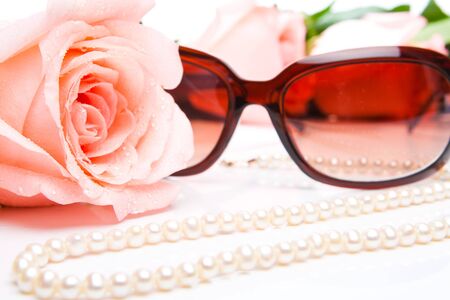 Pink rose, necklace and sunglasses. Shallow focus on roseの写真素材