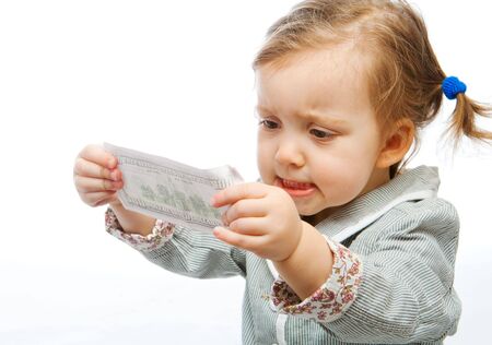 Displeased baby girl looking at the hundred dollars banknoteの写真素材