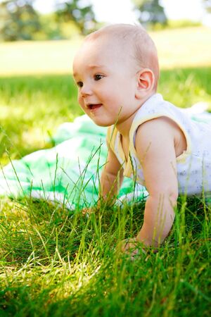Cute smiling  baby in the summer parkの写真素材