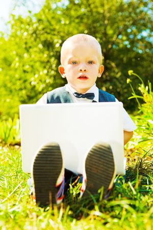 Toddler with laptop, sitting in the parkの写真素材