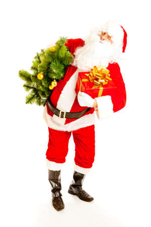 Santa Claus carrying Christmas tree and a presnt boxの写真素材