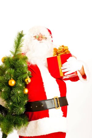 Santa Claus carrying Christmas tree and a present boxの写真素材