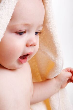 Closeup portrait of a baby covered with towelの写真素材