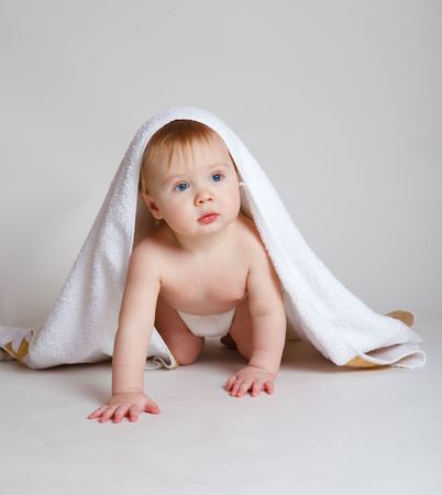 Baby in diaper covered with towel, over grayの写真素材