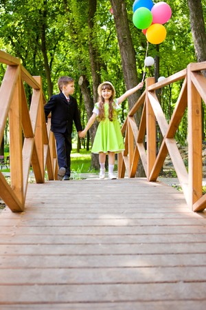 Preschool boy in suit and a lovely girl enjoying time togetherの写真素材