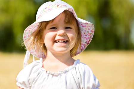 Pleased little girl in wheatの写真素材
