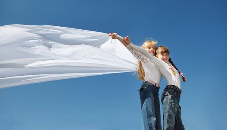 Kids in white against blue skyの写真素材