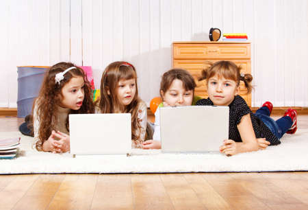 Four little friends lying on the floor with laptops