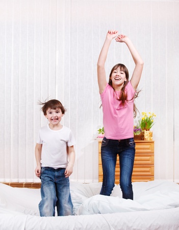 Two kids jumping on bedの写真素材