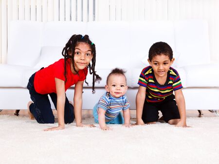 Three kids crawling in the roomの写真素材
