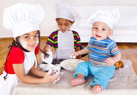 Three african american kids playing with flourの写真素材