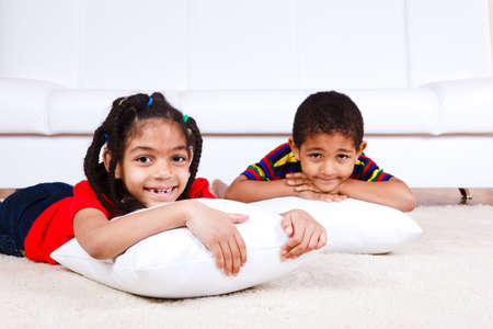 Laughing kids lying with pillowsの写真素材