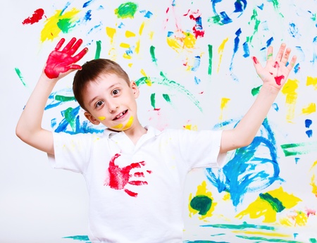 Portrait of a preschool boy waving his hands painted in red の写真素材
