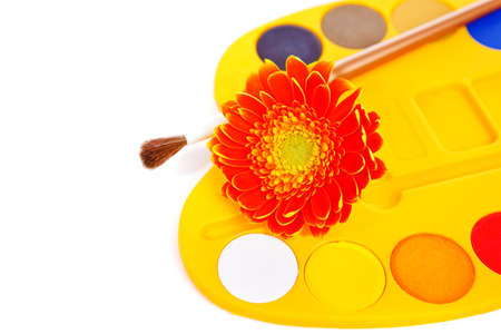 Palette of watercolor paints with a paintbrush and fresh flower onの写真素材