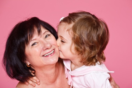 Curly little girl kissing grandmotherの写真素材