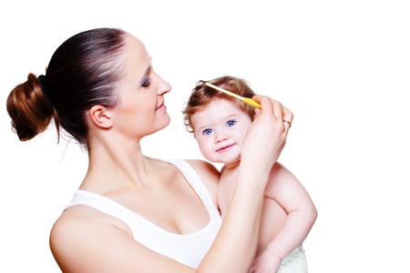 Loving mother combing baby hairの写真素材