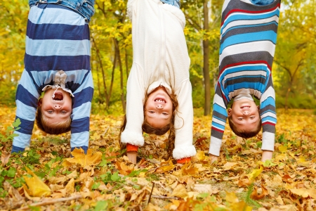 Three  kids upside down in autumn parkの写真素材