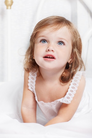 Portrait of a little girl lying in bedの写真素材