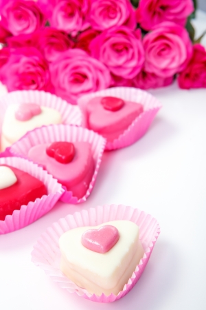 Pink and white sweets and roses in the backgroundの写真素材