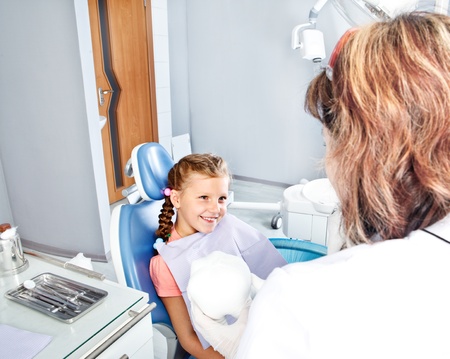 Little smiling patient looking at dentistの写真素材
