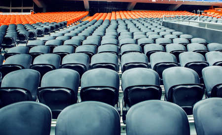 Empty rows of dark and orange sport stadium chairsの写真素材