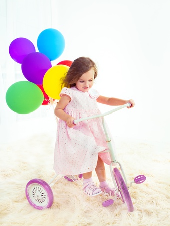 Indoor cycling on a white and pink kids bikeの写真素材