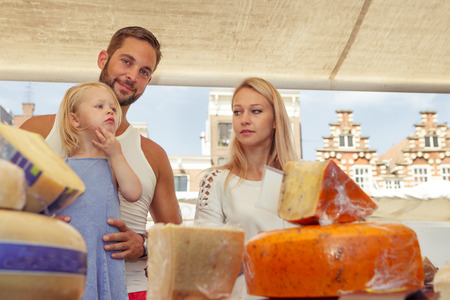 Family buying traditional Dutch  cheese at the local  outdoor marketの写真素材