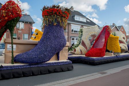 HILLEGOM, THE NETHERLANDS - APRIL 23, 2016: Moving platform with a huge frame made in a form of boots and shoes decorated with spring flowers. Taking part in the  traditional flowers parade "Bloemencorso".のeditorial素材
