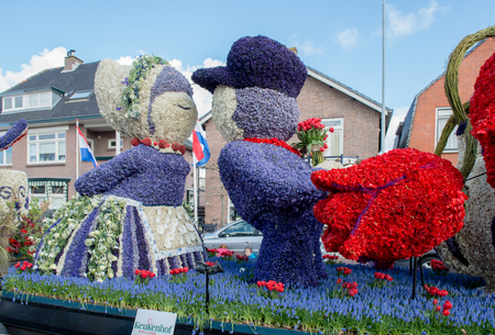HILLEGOM, THE NETHERLANDS - APRIL 23, 2016: Moving platform with a huge frame made in a form of a traditional Dutch kissing couple and  decorated with spring flowers. Taking part in the  traditional flowers parade "Bloemencorso".のeditorial素材