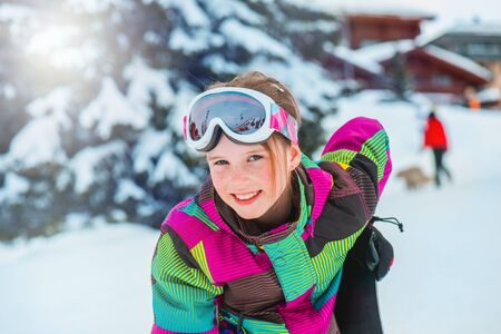 Happy kid in ski outfit and goggles at the ski resortの写真素材