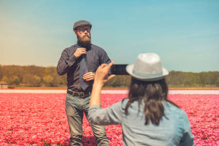 Young man with beard standing in a tulip field