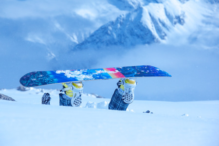 Legs of a snowboarder stuck in deep snow upside downの写真素材