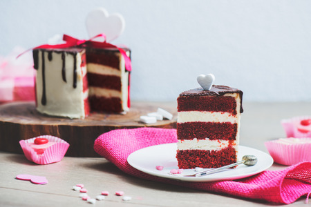 Slice of a red velvet cake with heart shaped decoration on the pink sackcloth の写真素材
