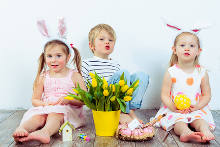 Attractive preschool boy and two girls celebrating Easterの写真素材