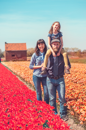 Happy loving family with a kid in a Dutch tulips field の写真素材