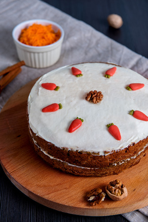 Carrot cake with sugar decoration on top, on wooden cutting boardの写真素材