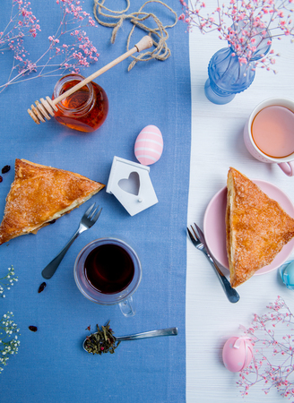 Apple turnovers served with tea along with pink Easter eggs decorationの写真素材