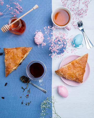Apple turnovers served with tea along with pink Easter eggs decorationの写真素材