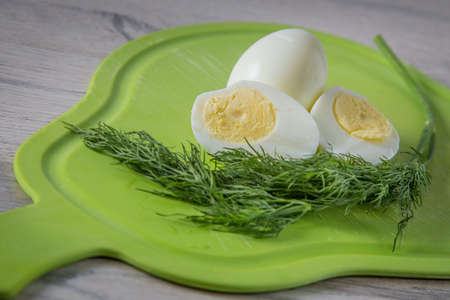 Eggs and dill on the board. Eggs cut with a knifeの写真素材