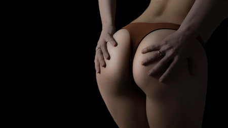 Buttocks of sexy womans hips on black backgroundの写真素材