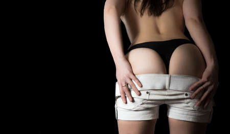 Woman taking off white shortsの写真素材