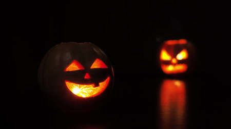 Young woman lights a candle in a pumpkin for Halloween. Preparation for the holiday. Sparkler.の写真素材