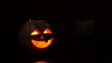 Young woman lights a candle in a pumpkin for Halloween. Preparation for the holiday. Sparkler.の写真素材
