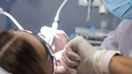 Young woman dentist. Reception at the orthodontist. Replacement of braces. Polishing. Gel bonding.の写真素材