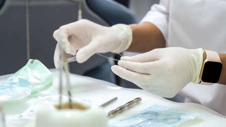 Young woman dentist. Prepares the instrument for the patient.