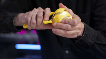 Young novice bartender trainee preparing a cocktail Cuts lemon for non-alcoholic lemonadeの写真素材